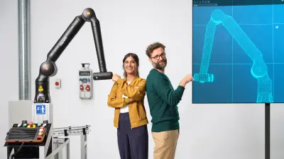 Deux associés jouent au baby-foot avec un robot d'assistance Bosch Rexroth APAS..
